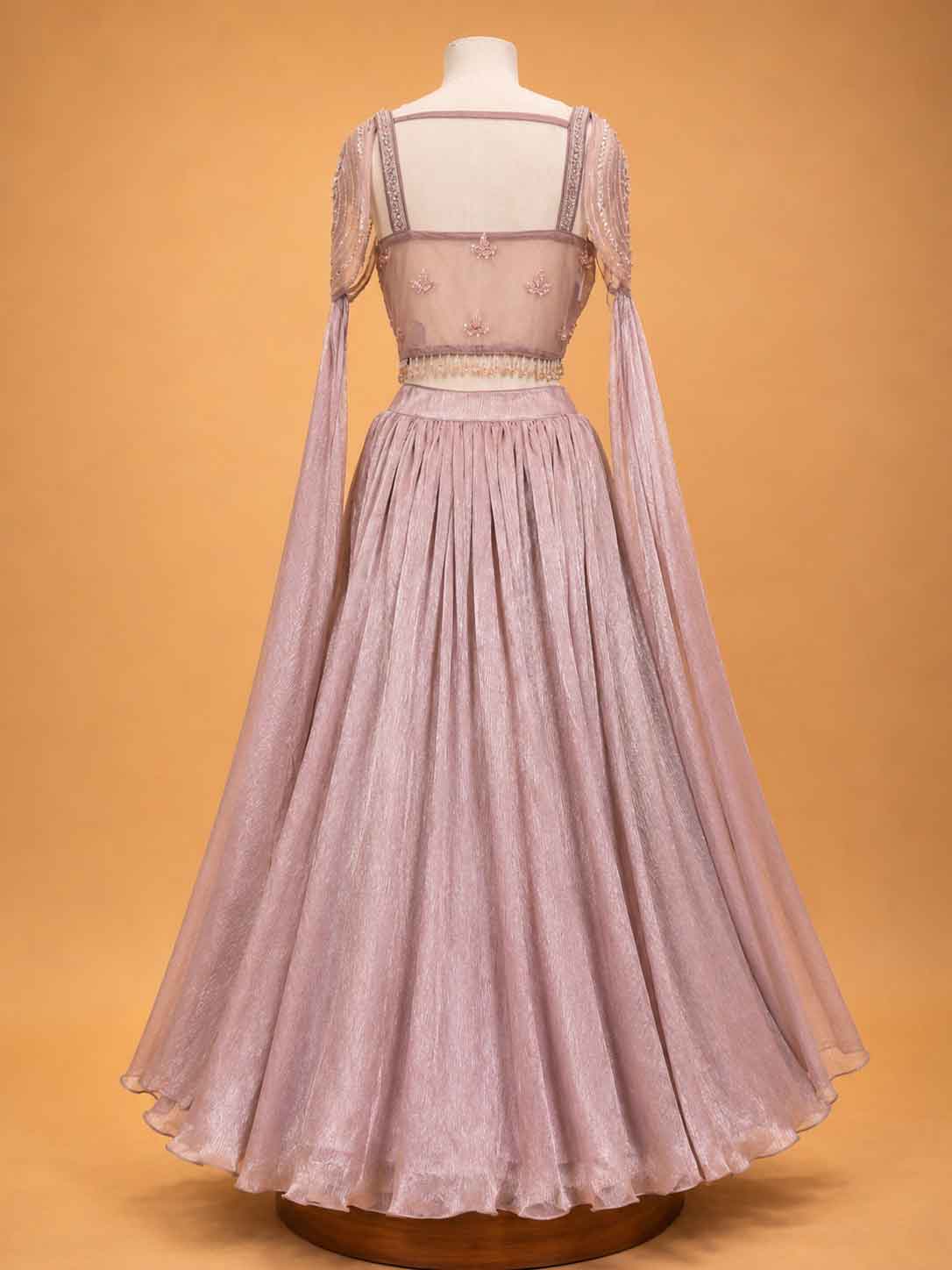 Peach colour embellished designer lehenga set for women with flared skirt and sheer sleeves