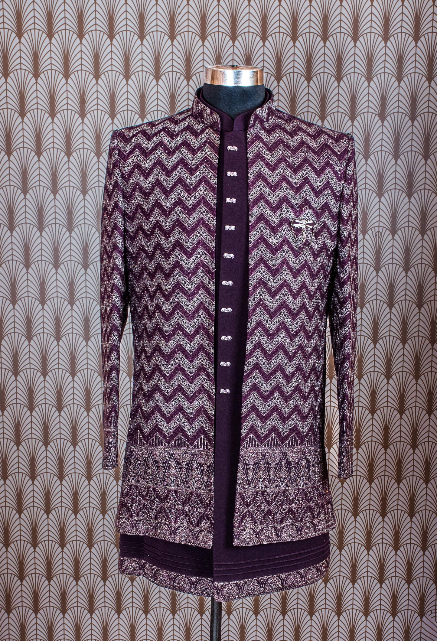 Elegant plum purple sherwani with all-over embroidery and brooch, paired with tailored trousers. Perfect for weddings, receptions, and festive wear.