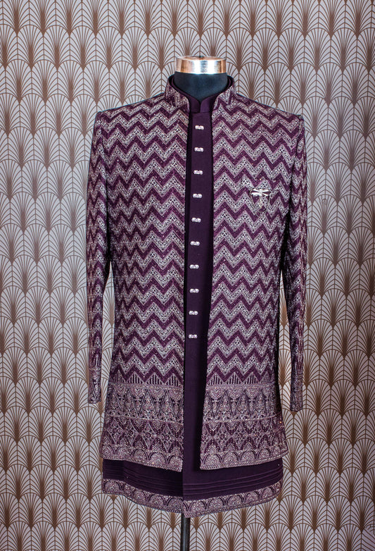 Elegant plum purple sherwani with all-over embroidery and brooch, paired with tailored trousers. Perfect for weddings, receptions, and festive wear.