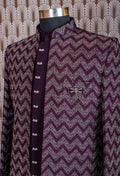Elegant plum purple sherwani with all-over embroidery and brooch, paired with tailored trousers. Perfect for weddings, receptions, and festive wear.