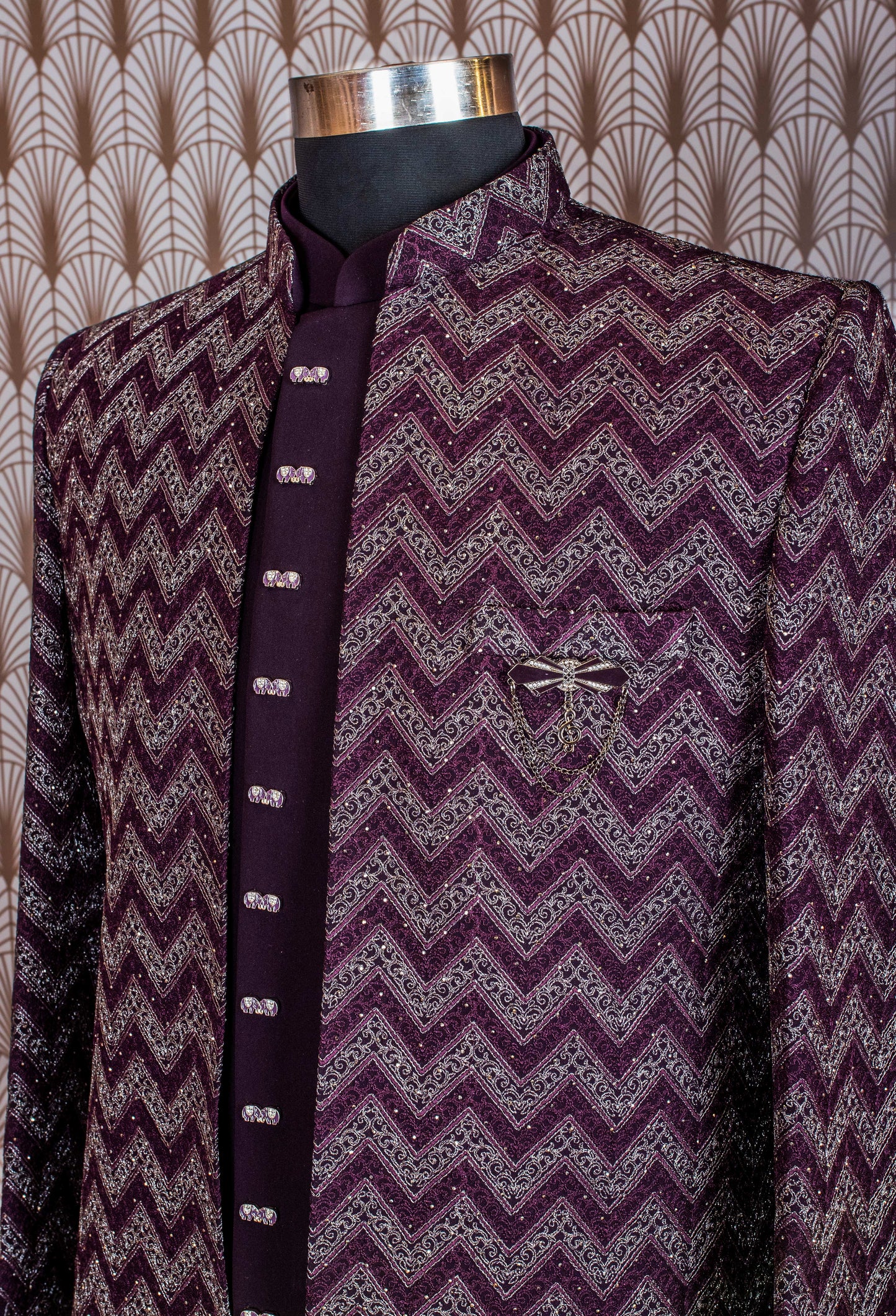 Elegant plum purple sherwani with all-over embroidery and brooch, paired with tailored trousers. Perfect for weddings, receptions, and festive wear.