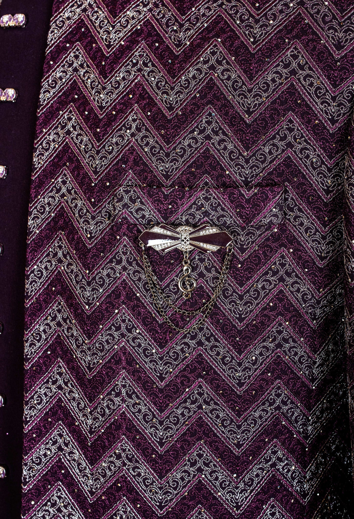 Elegant plum purple sherwani with all-over embroidery and brooch, paired with tailored trousers. Perfect for weddings, receptions, and festive wear.